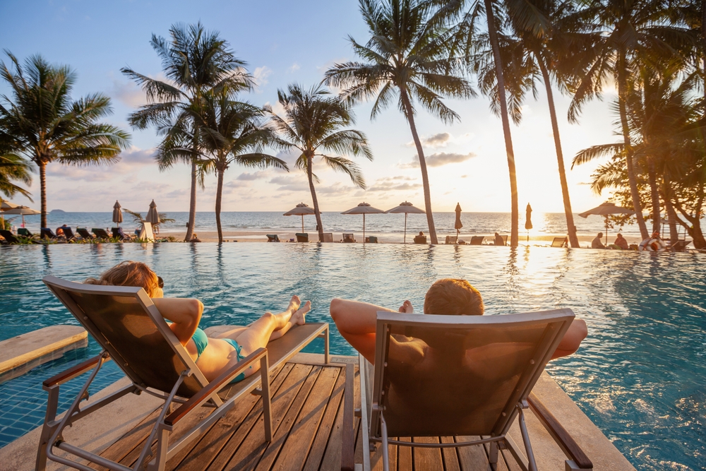 Vacation,,Couple,On,The,Beach,Near,Swimming,Pool,,Luxury,Travel